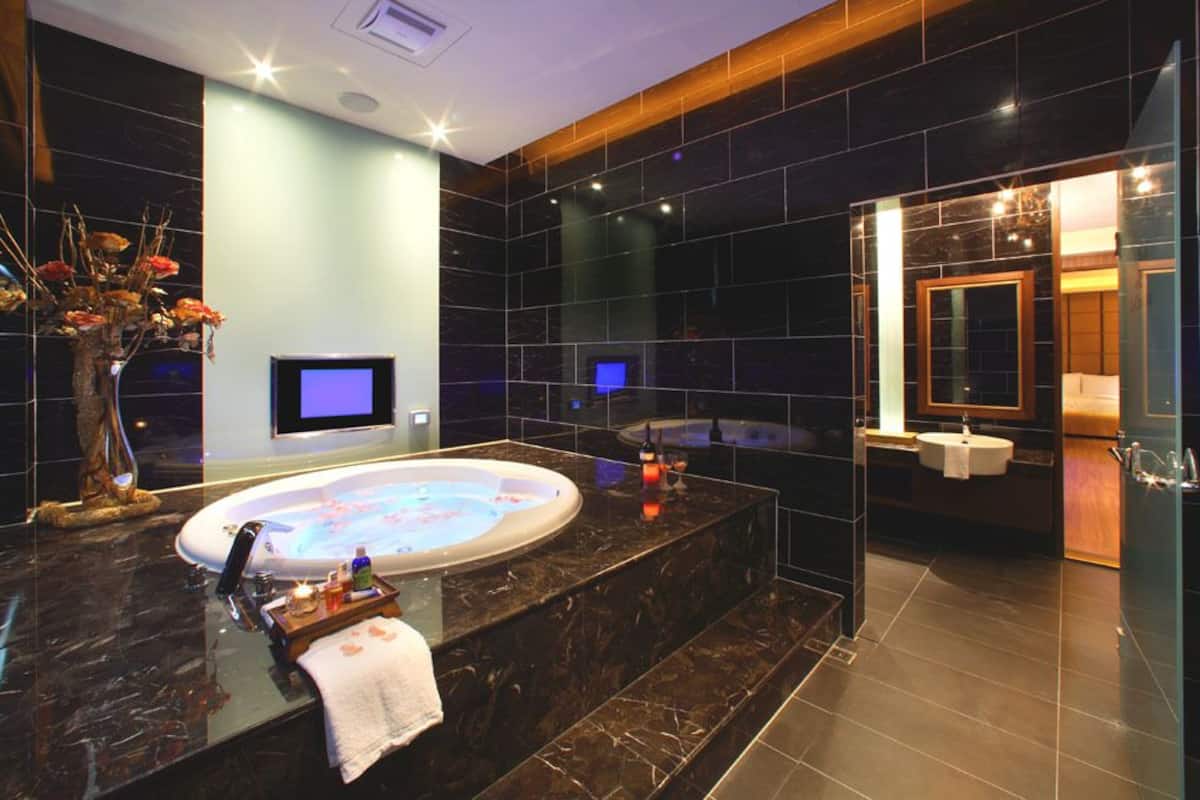 Une salle de bain moderne dotée d’une grande baignoire, d’une douche séparée et d’un meuble-lavabo.
