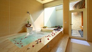A modern bathroom with a large bathtub, a shower, and a glass door leading to an outdoor area. - Le Chateau Hotel (Zhushan)