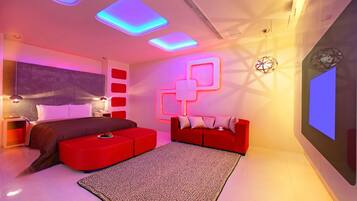 Un dormitorio moderno con un sofá rojo, una cama grande y un diseño de pared original.