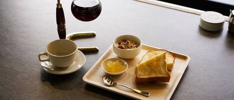 A breakfast tray with toast, a bowl of cereal, a cup, and a small bowl of jam.