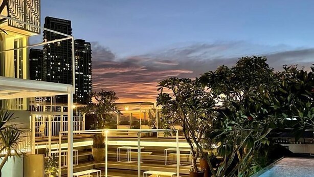 A rooftop pool with a view of city buildings at sunset. - Kemang Icon Hotel (Jakarta)