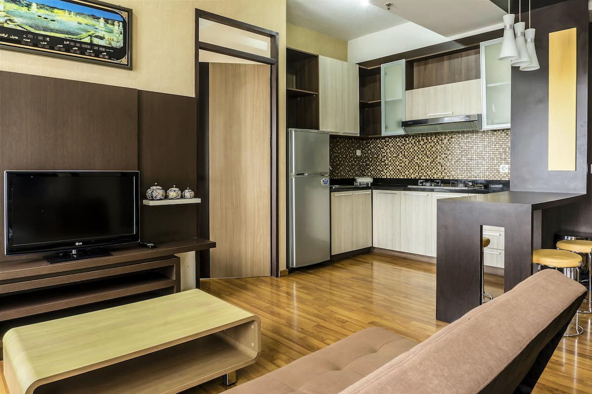 Una cocina moderna con horno integrado, refrigerador y comedor con banco y taburetes.