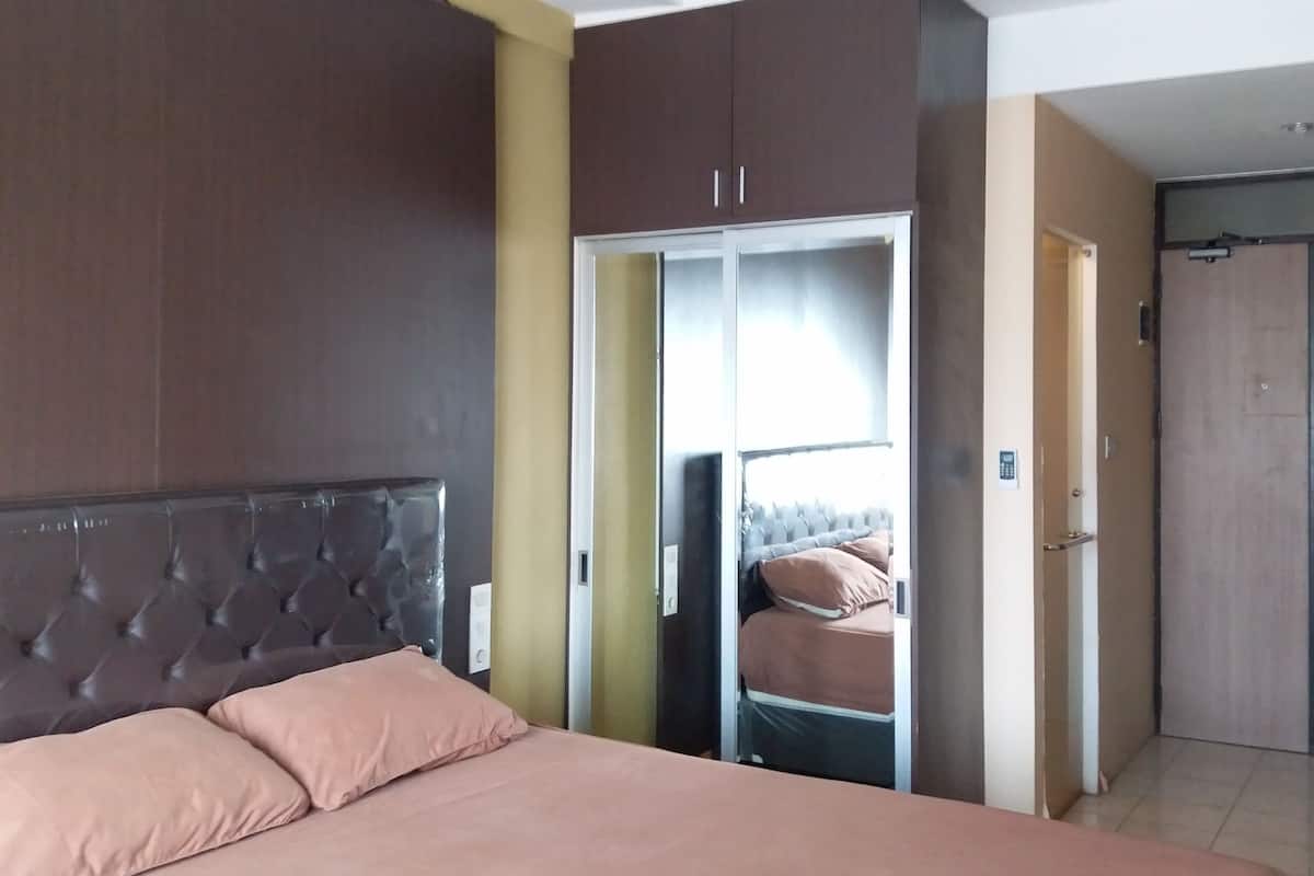 Un dormitorio con una cama grande, un armario y un closet con puerta corrediza.