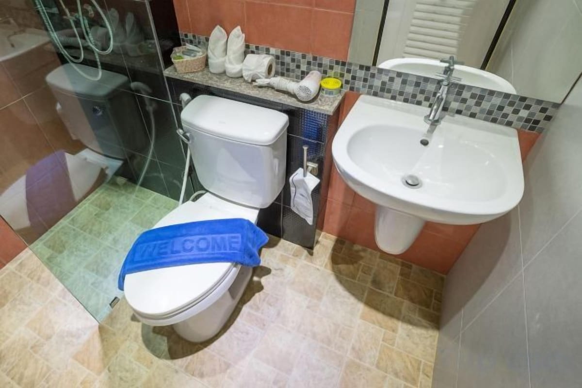 Un baño con inodoro, lavamanos y zona de ducha.