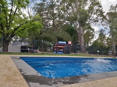 Una piscina al aire libre de temporada, sombrillas. Euroa Caravan Park