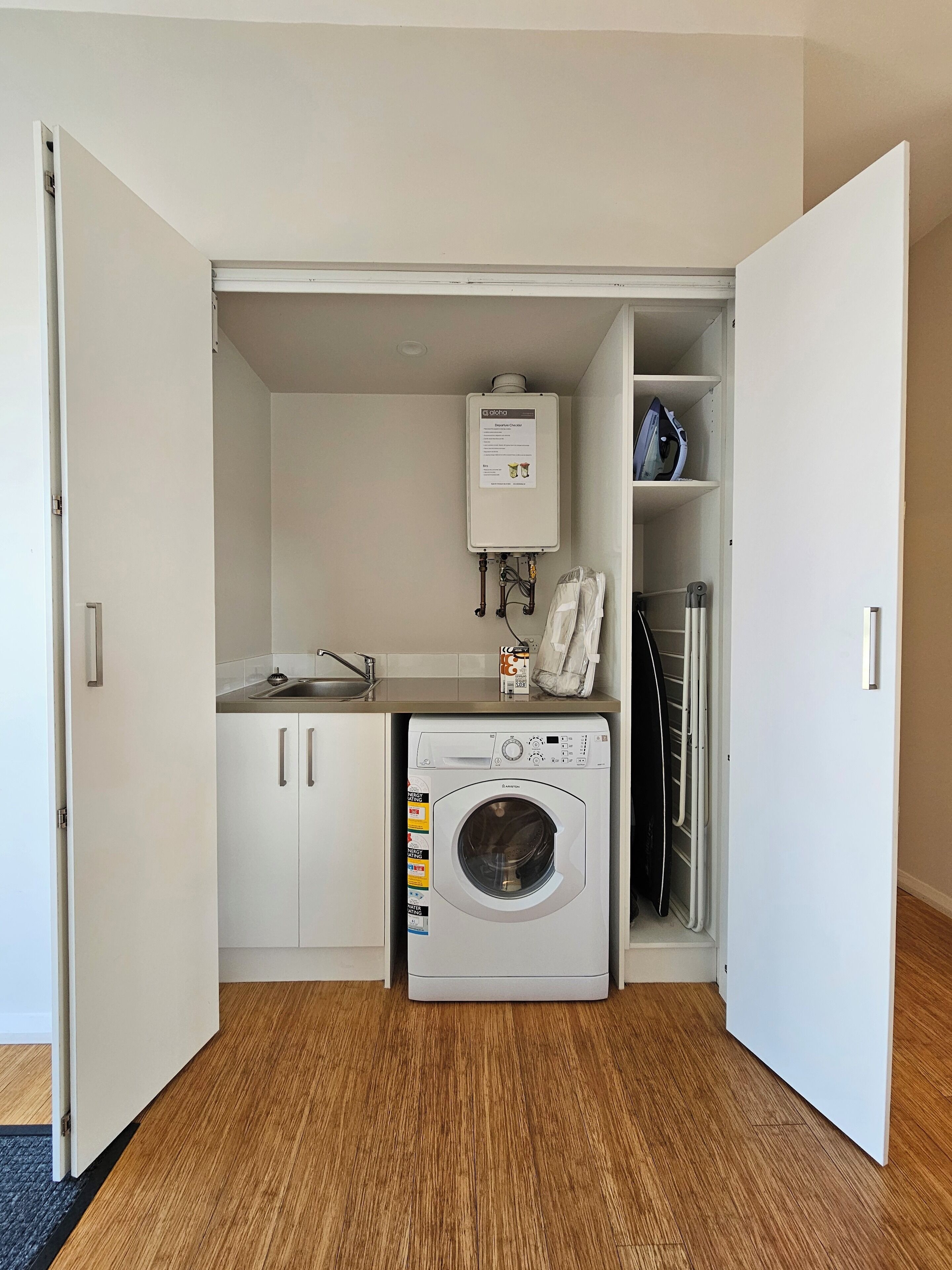 Ein kleiner Hauswirtschaftsraum mit Waschmaschine, Trockner und Warmwasserbereiter.