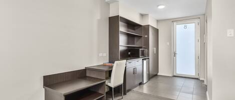 A modern kitchen with built-in appliances, a dining area with a small table and chair, and a door marked with the number 8.