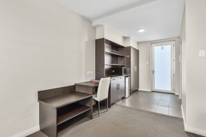 A modern kitchen with built-in appliances, a dining area with a small table and chair, and a door marked with the number 8.