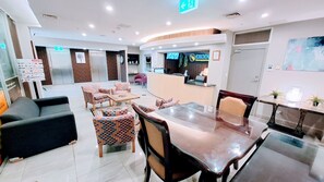 A hotel lobby with a reception desk, seating area, and a staircase. - Exodus Dandenong Apartment Hotel (Melbourne)