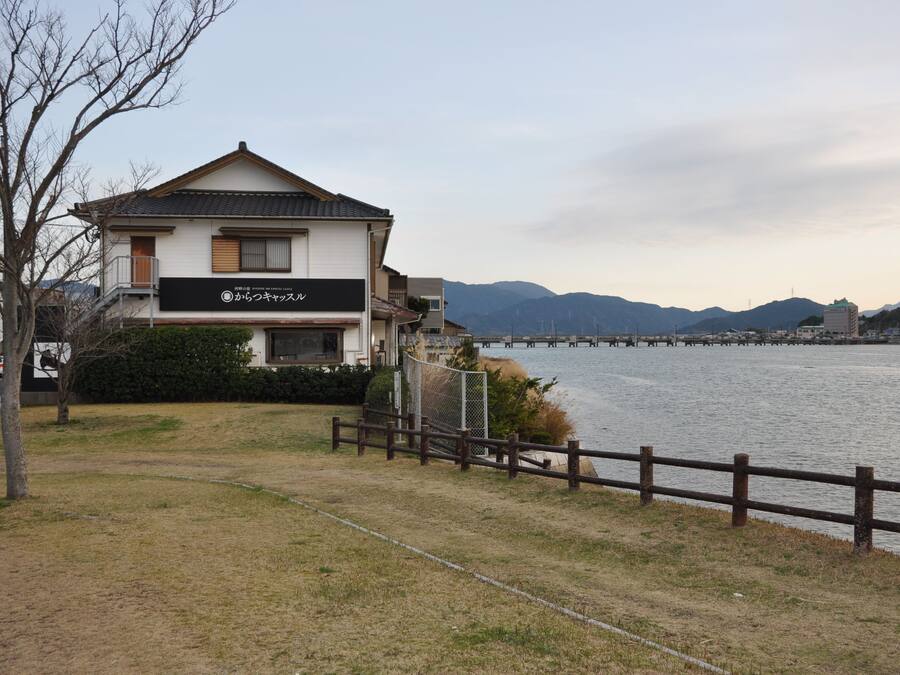 A building with a sign that reads "from the sky" near a body of water with a bridge in the background.