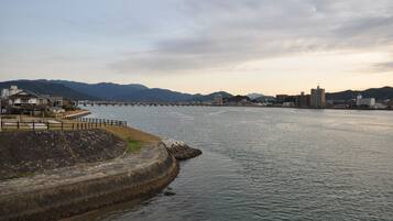 A waterfront view with a bridge, buildings, and mountains in the background.