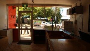 Un restaurante con un amplio ventanal, una barra y un refrigerador.