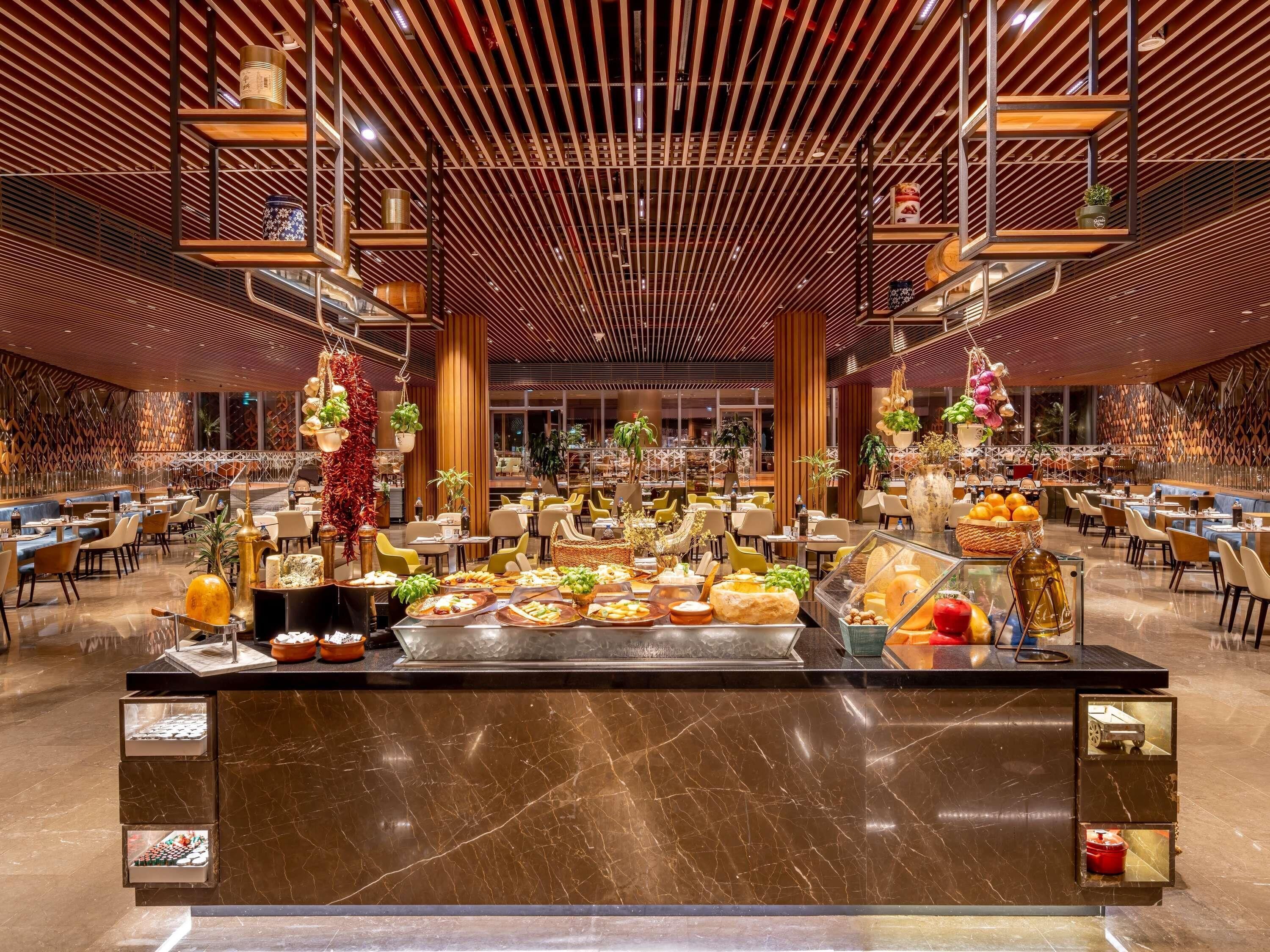 Un espace buffet spacieux proposant une grande variété de plats, un comptoir central pour le service et un design de plafond moderne.