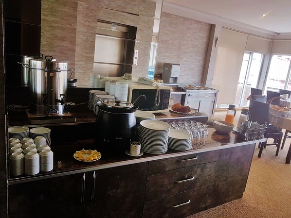 A kitchen with a coffee station, a microwave, and a bread display. - Kent Otel (Samsun)
