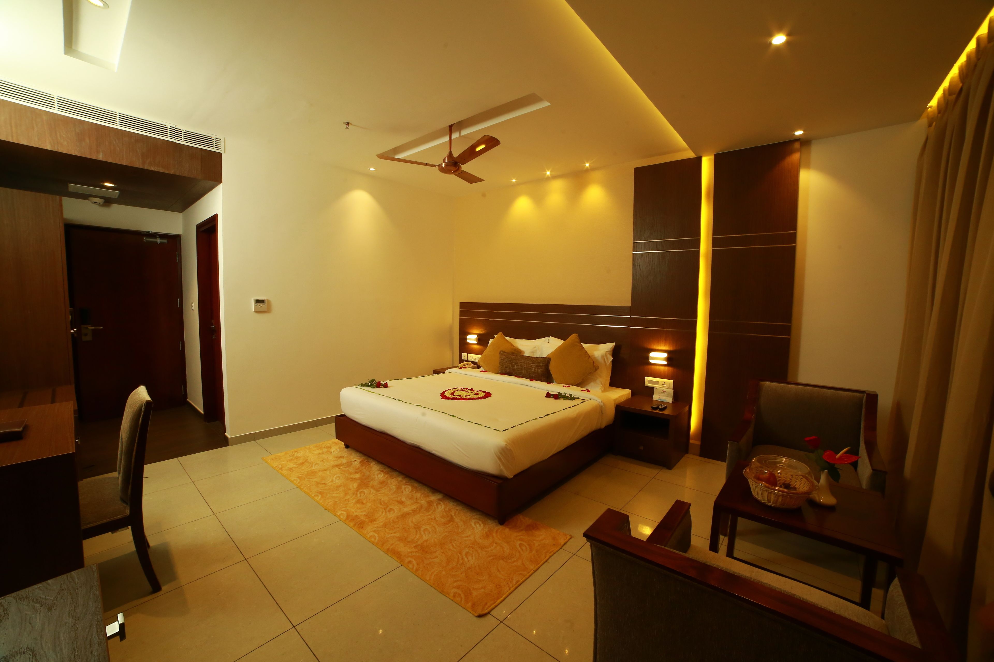 A modern hotel room with a large bed, a desk, and a chair.