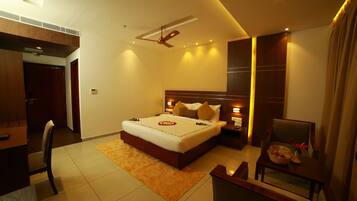 A modern hotel room with a large bed, a desk, and a chair.