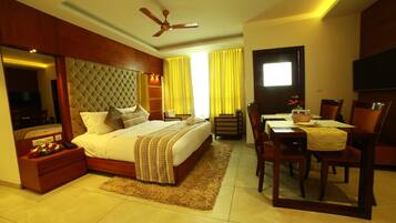 A bedroom with a bed, bedside table, and a desk with chairs.