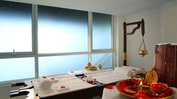 Experience a serene spa setting with a massage table, traditional cabinet, and elegant touches.