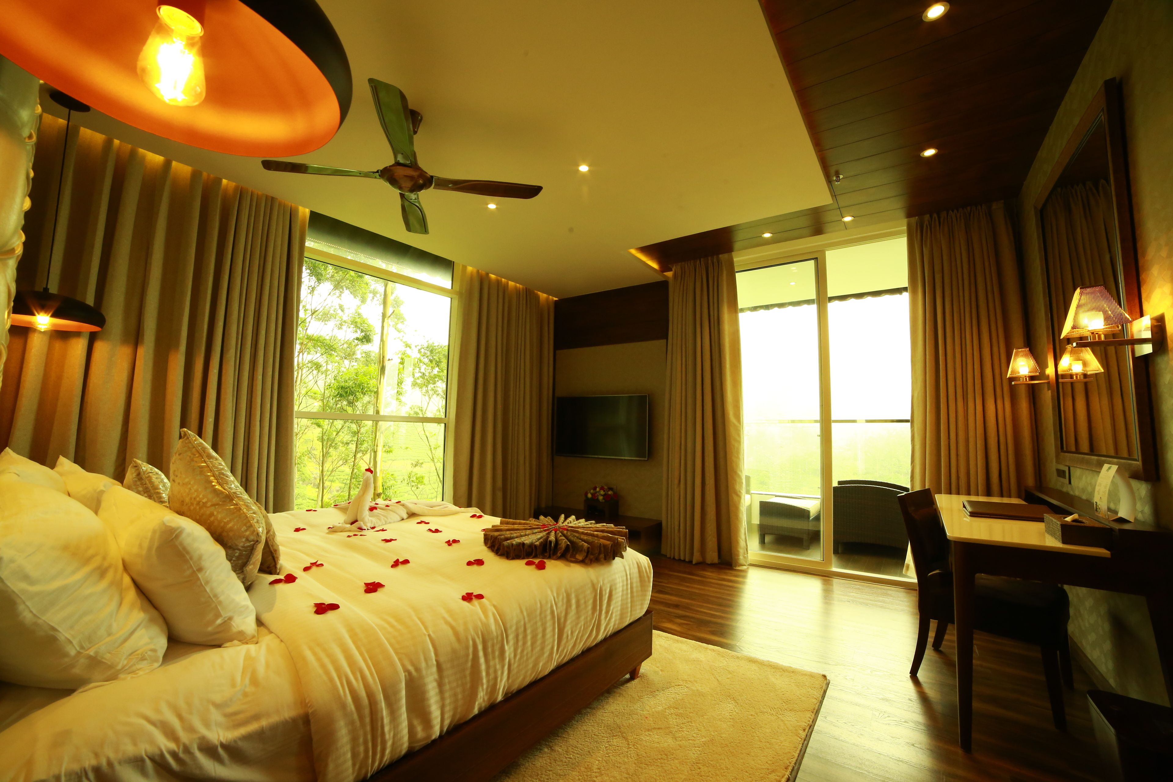 A spacious bedroom with a large bed, a desk, and a view of the outdoors.
