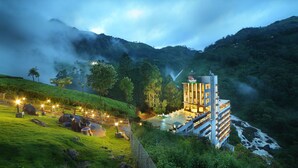 Un hotel con diseño moderno, situado en una zona montañosa y exuberante.
