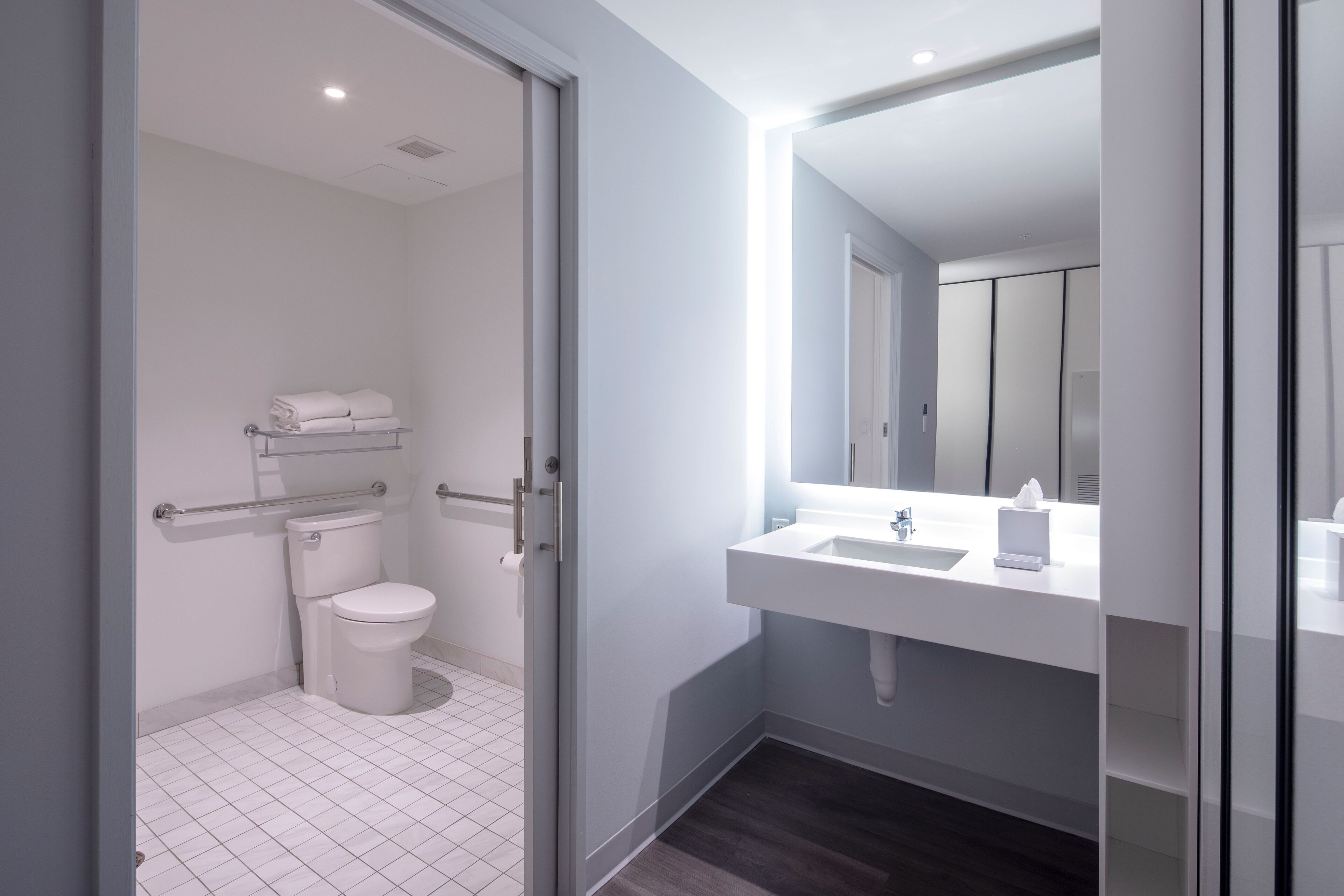 Une salle de bain moderne avec des toilettes, un lavabo et un miroir.