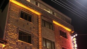 Un hotel con fachada de ladrillo y señalización iluminada.