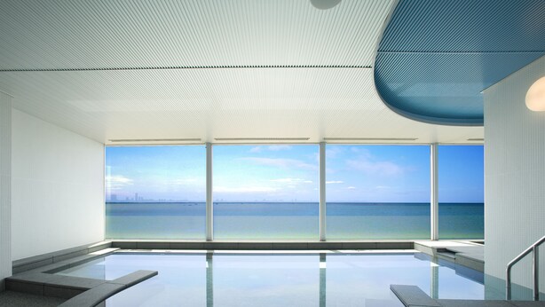 Piscina interior moderna con vistas despejadas al océano y al horizonte urbano.
