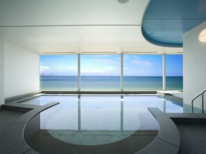 A modern indoor pool with a clear view of the ocean and city skyline. - Mitsui Garden Hotel Prana Tokyo Bay (Urayasu)