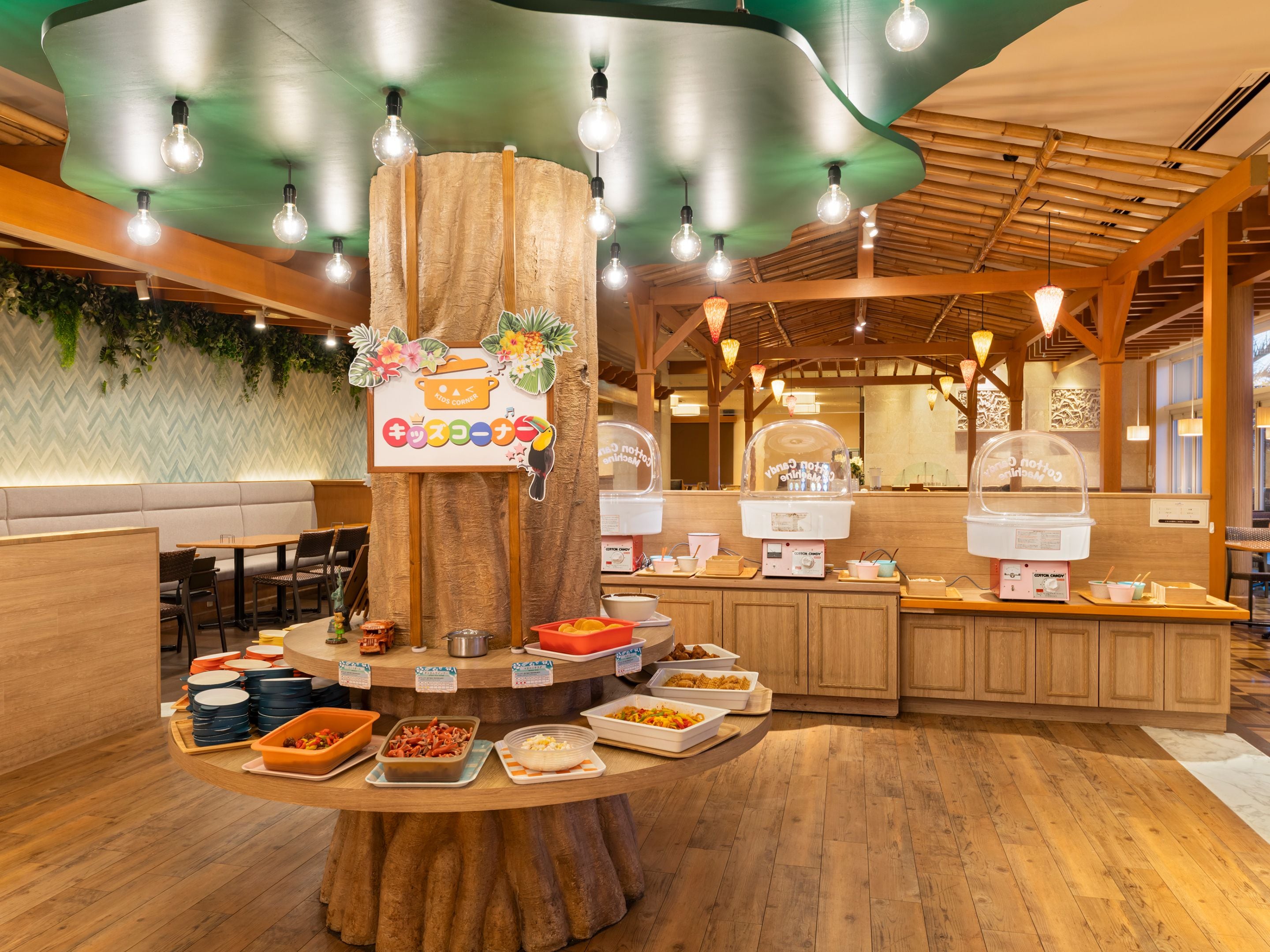 A buffet setup with a central wooden tree trunk, various food dishes, and a sign indicating a coffee station.