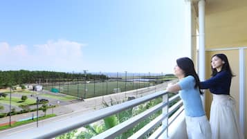 A balcony with a view of a sports field and a road.