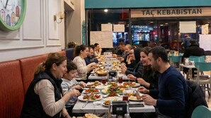 A restaurant with multiple tables and booths, a clock on the wall, and a sign for 'TAC KEBABİSTAN' in the background.