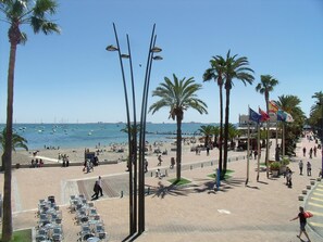 A beachside promenade with palm trees, outdoor seating, and a view of the sea. - La Obrera (San Javier)