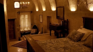 A room with a vaulted ceiling, a bed, a desk, and a window with curtains. - Hanımkız Konagi (Avanos)
