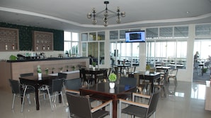 Un restaurante moderno con zona de bar, mesas y sillas para comer.