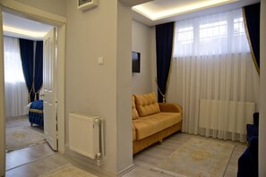 Deluxe Family Apartment | Wohnbereich | 32-Zoll-LCD-Fernseher mit Satellitenempfang, Fernseher