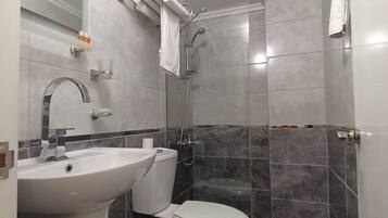 Ein modernes Badezimmer mit Waschbecken, Toilette und Dusche.