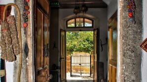 A hallway with a checkered floor, wooden doors, and a decorative archway. - Saklı Konak (Karaburun)