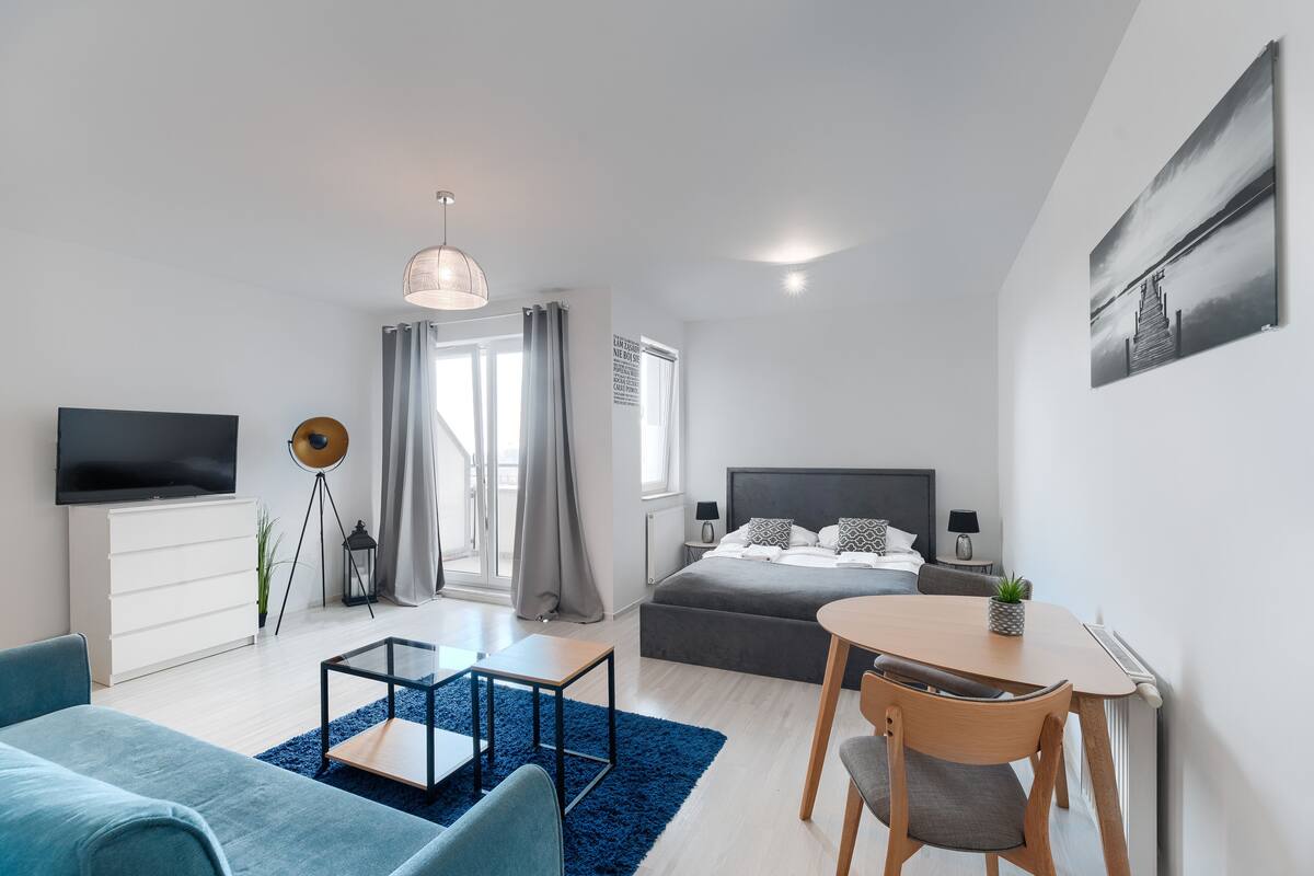 Une chambre d’hôtel moderne équipée d’un lit, d’une télévision, d’un bureau et d’un coin repas.