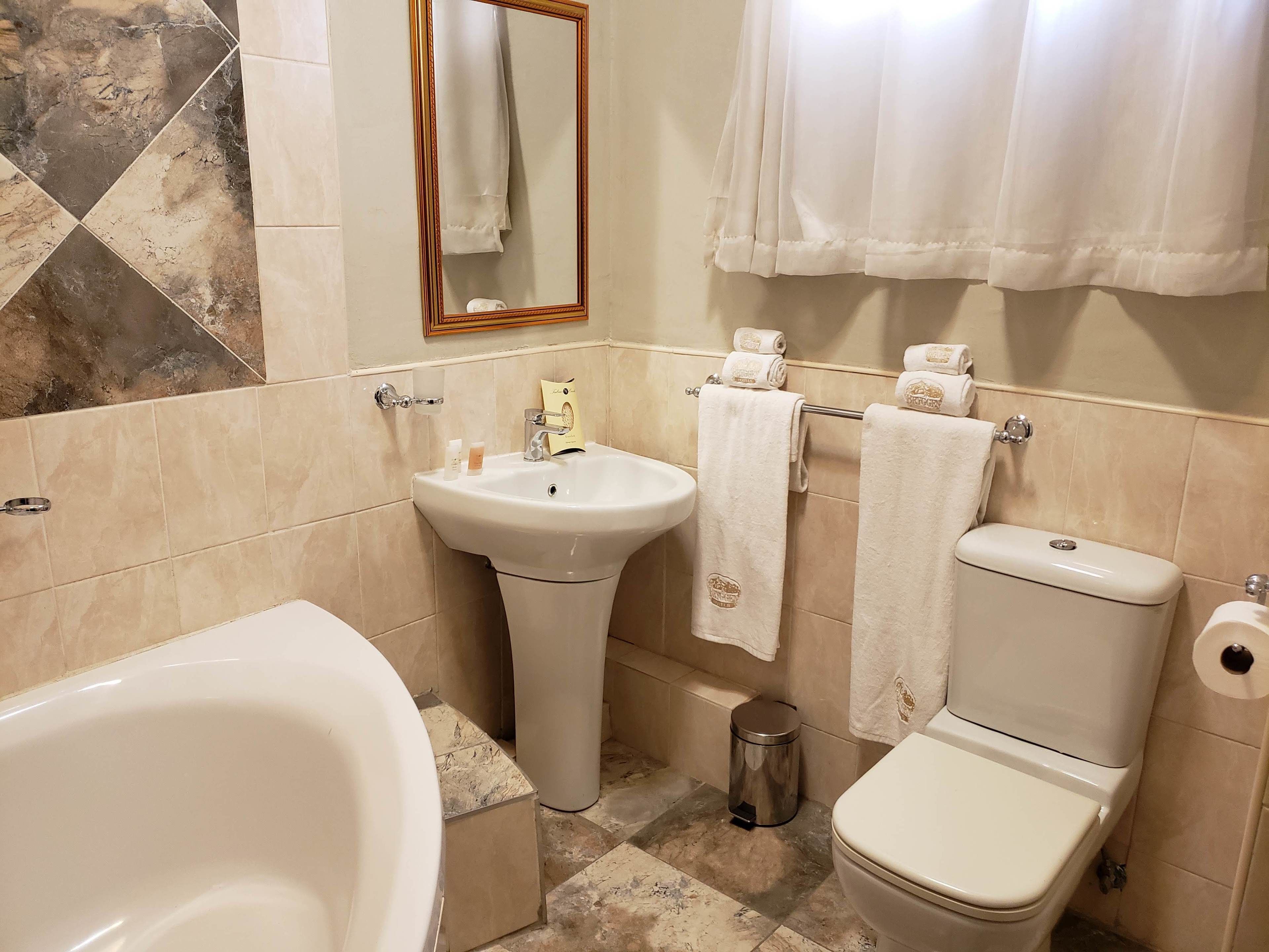 Un baño con bañera, lavabo, inodoro y espejo.