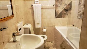 Un baño con lavamanos, inodoro y bañera.