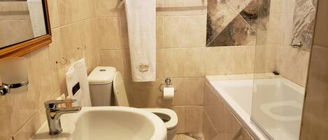 A bathroom with a sink, toilet, and bathtub.