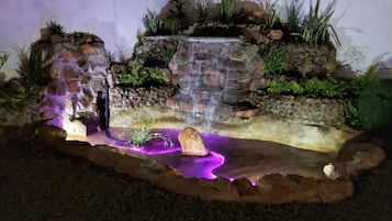 Experience serenity in this tranquil indoor garden, featuring a soothing waterfall and lush greenery.