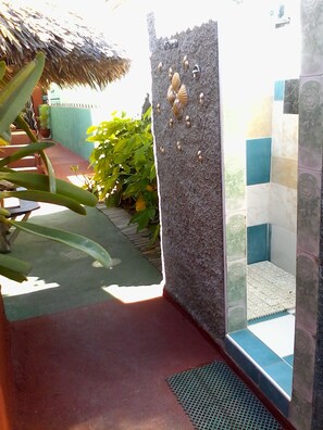 Bathroom features a shower area with a tiled wall and a small window.