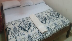 A bed with a patterned bedspread and two pillows. - Mountainview Backpackers Kisumu (Kisumu)