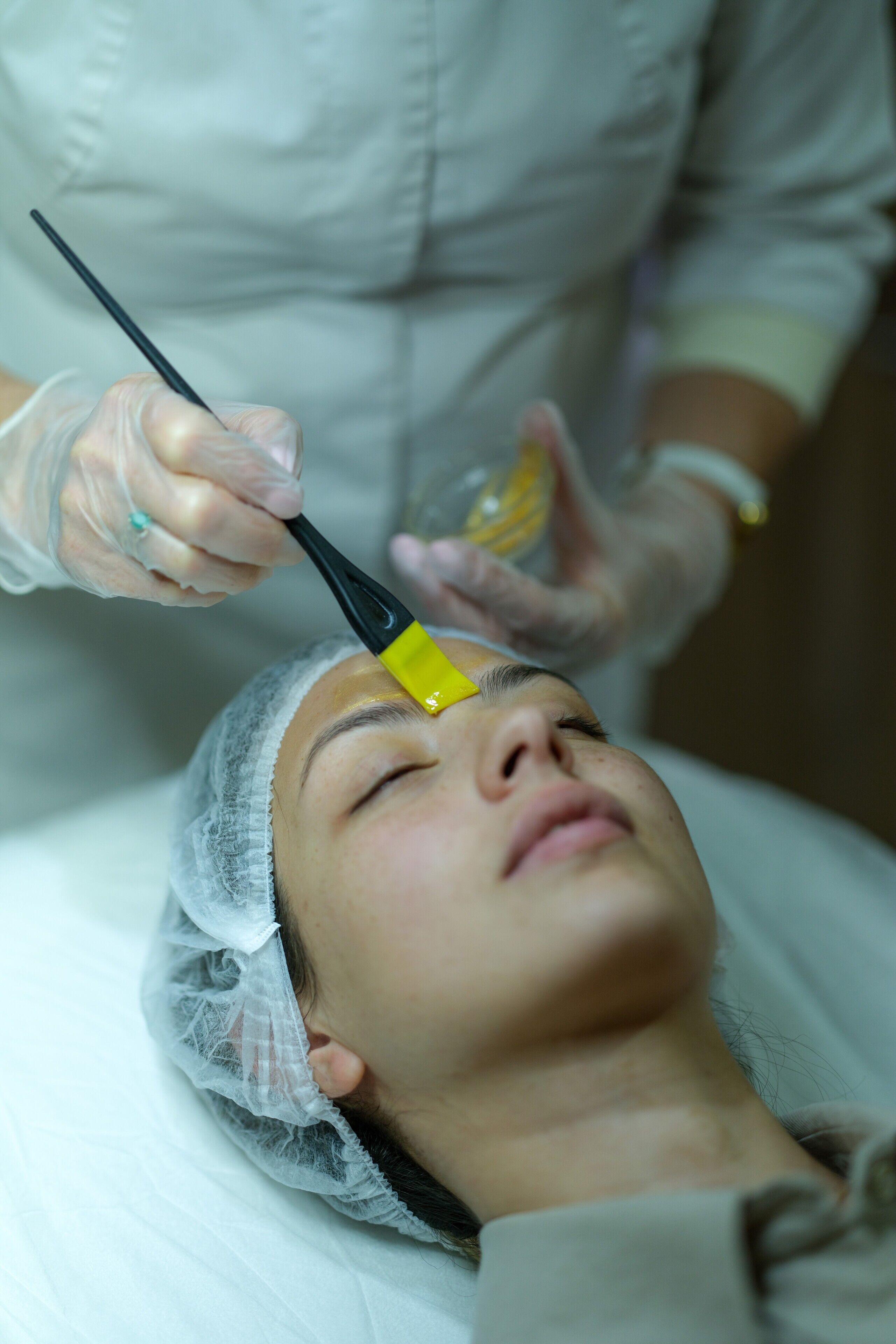A person receiving a treatment with a tool held by another individual.
