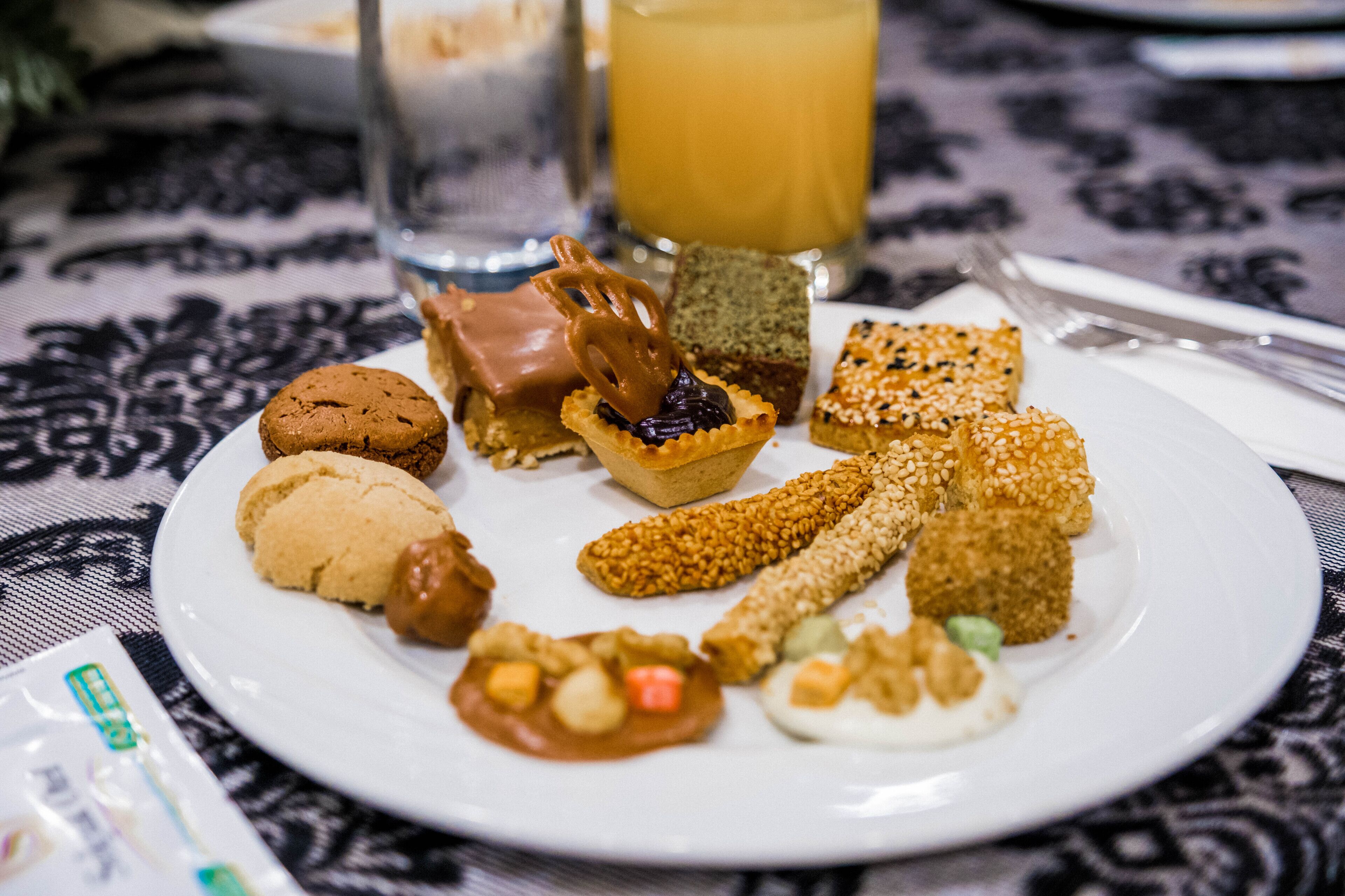 Un plato con una variedad de bocadillos, como galletas, pretzels y otros productos horneados.