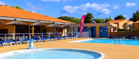 Een buitenzwembad en ligstoelen