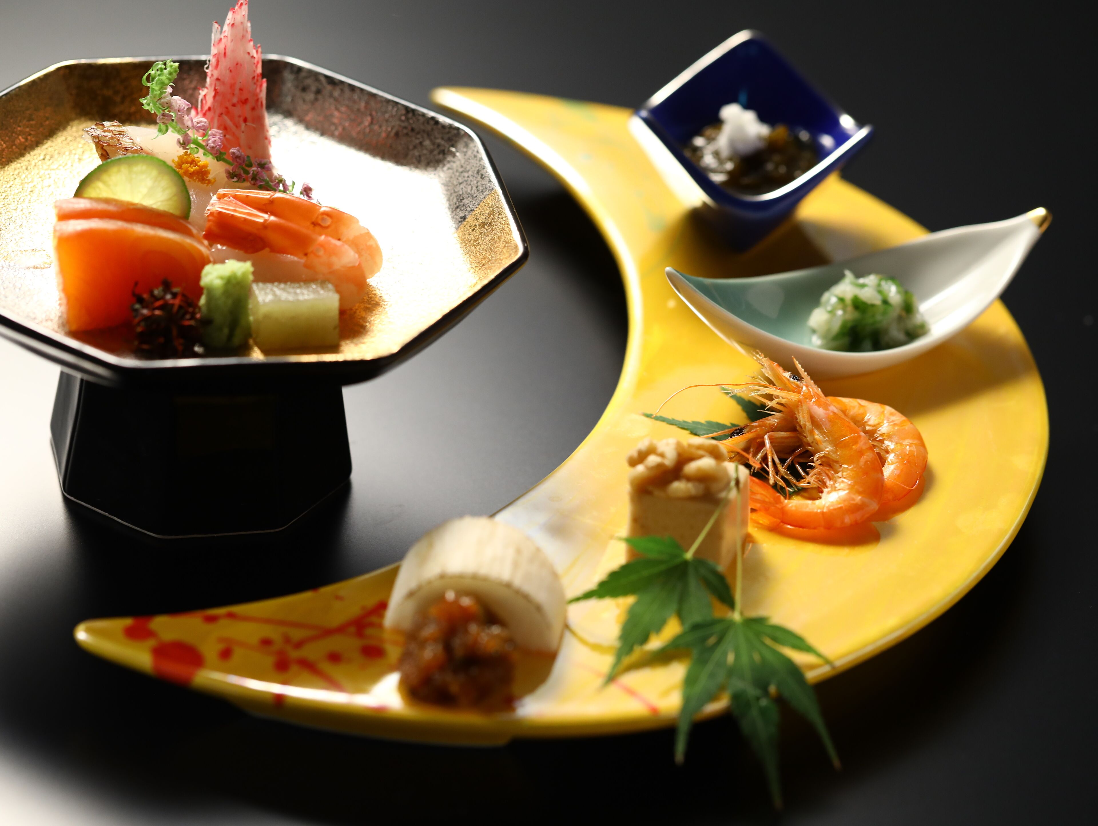 Diversos platos, incluyendo sushi y sashimi, sobre un plato amarillo.