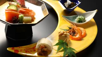 Diversos platos, incluyendo sushi y sashimi, sobre un plato amarillo.