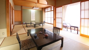 A traditional Japanese room with tatami flooring, a low table, and sliding doors. - Ogiwarakan (Chikuma)